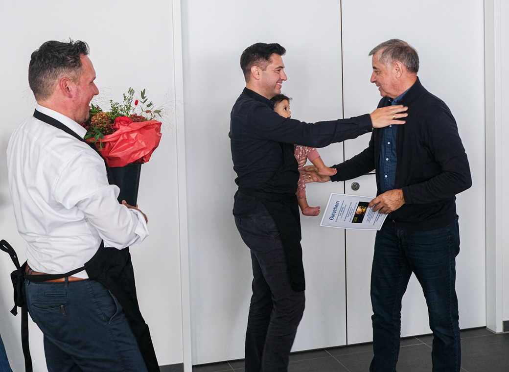 Simon Reuter and Daniel Sugg congratulate Harry Reuter and wish all the best for future with VIP tickets and a bouquet of flowers. Granddaughter Lou is also there.