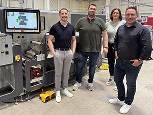 Mitarbeiter stehen vor einer Stanzer-Maschine in der Firma robos-labels.